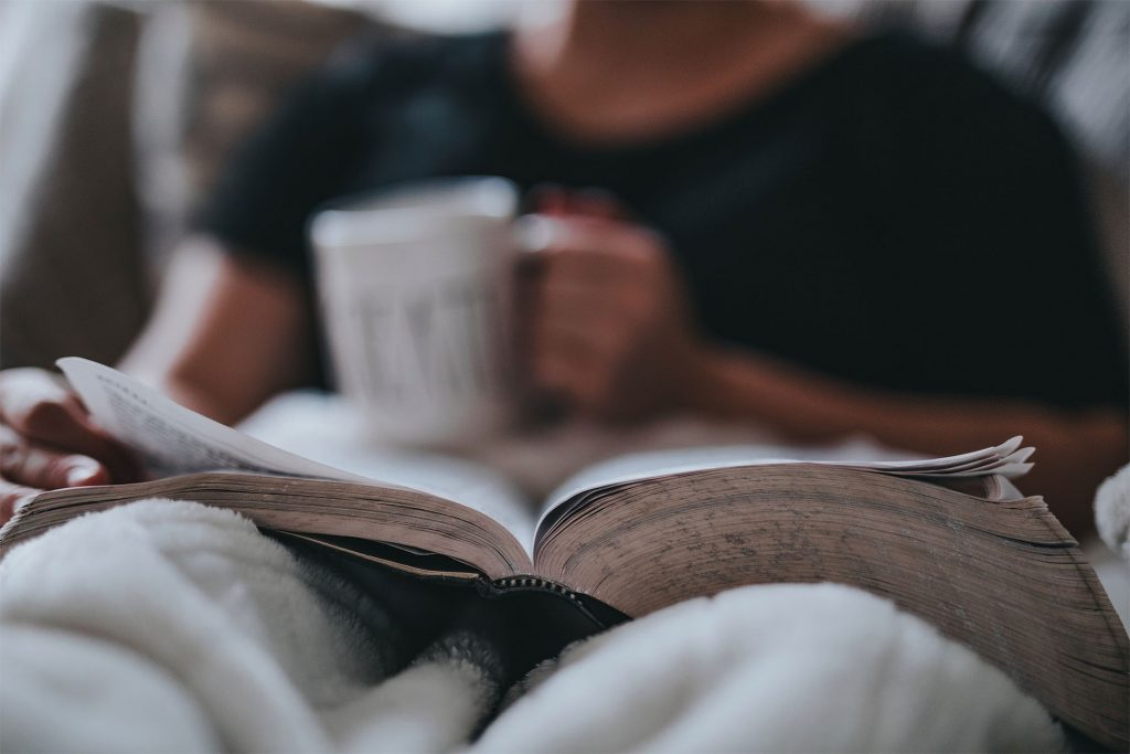 resident reading a book with a hot drink