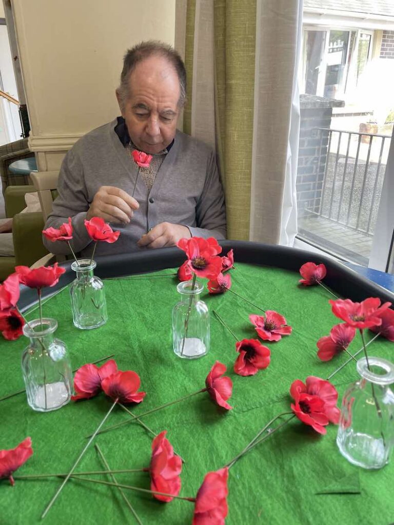resident putting poppies into glass holders