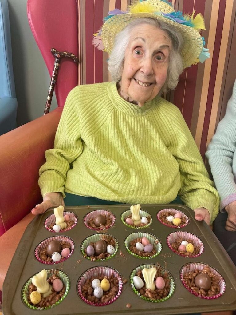 resident smiling with some easter nests in her hand