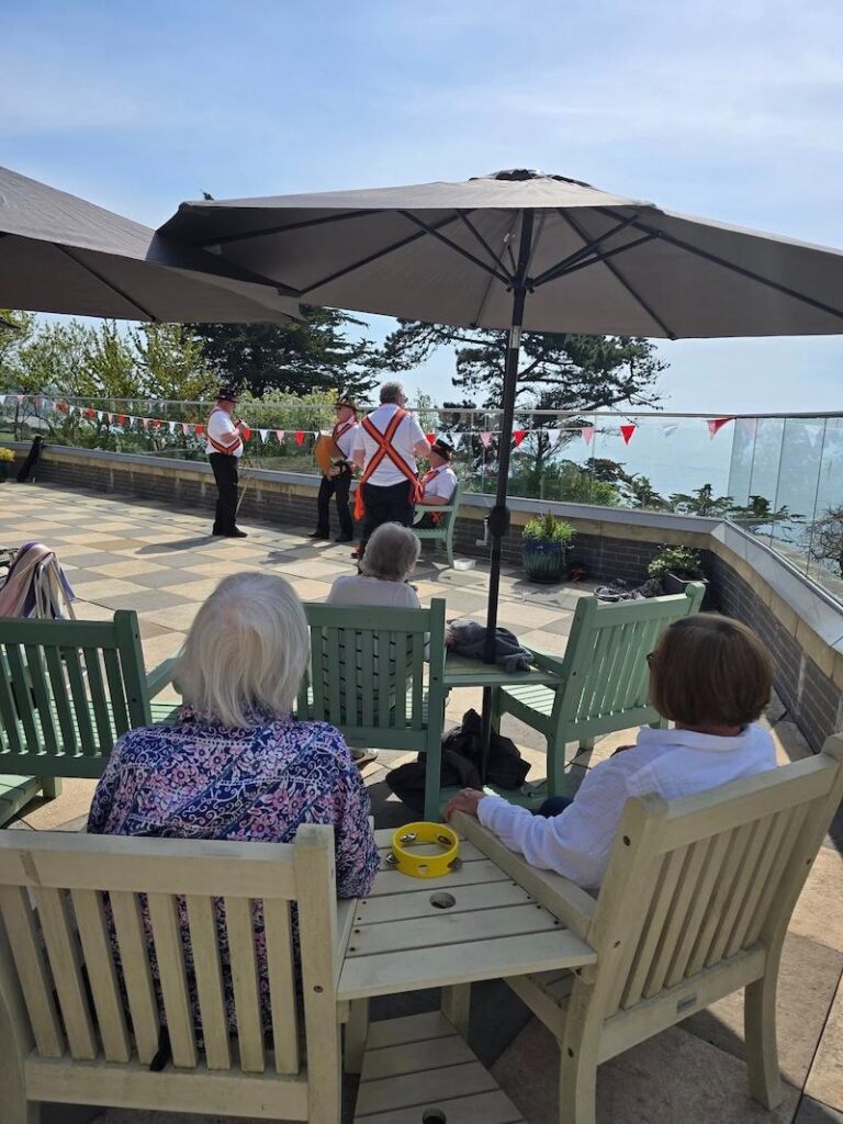 residents sat on the terrace together watching a performance