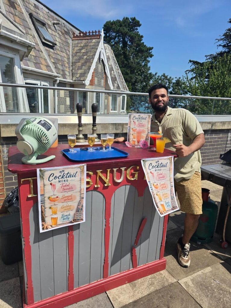 man next to a red cocktail bar